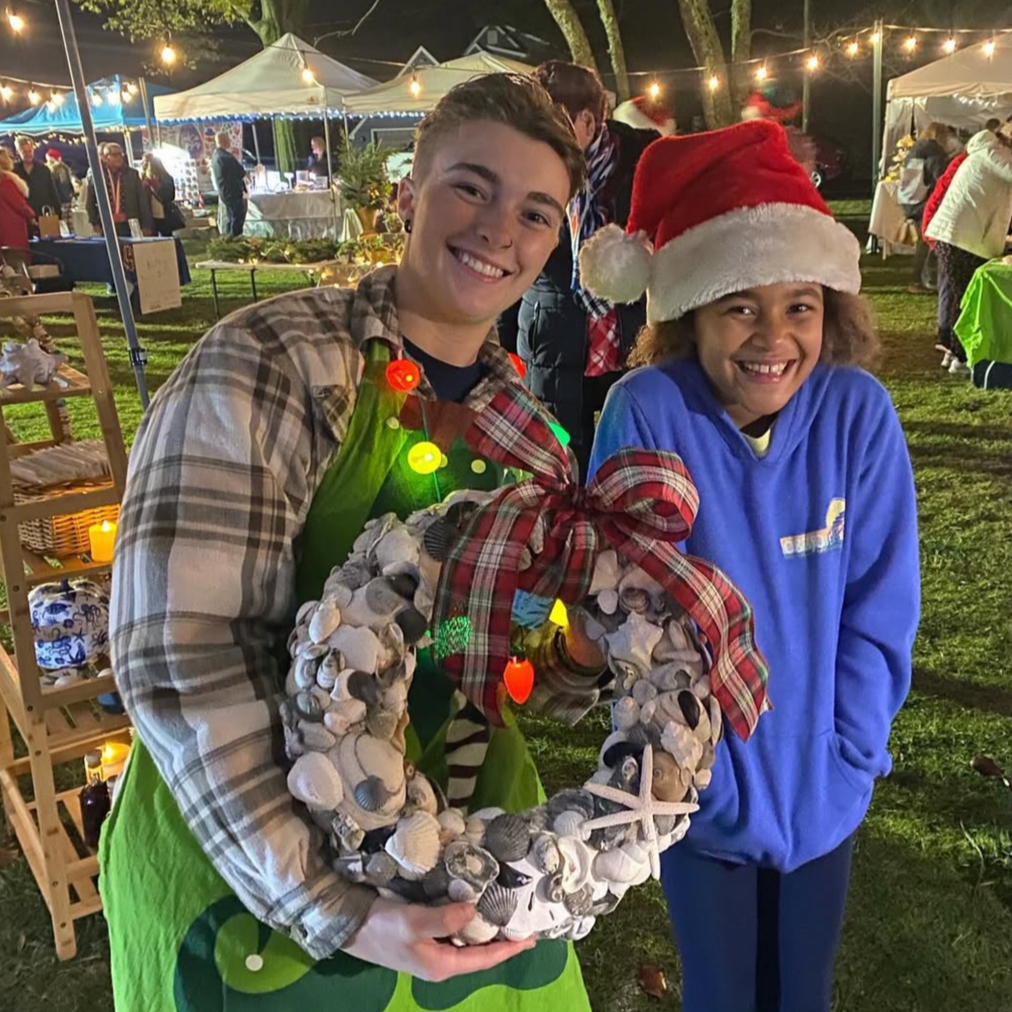 Happy customers with shell wreath at holiday market